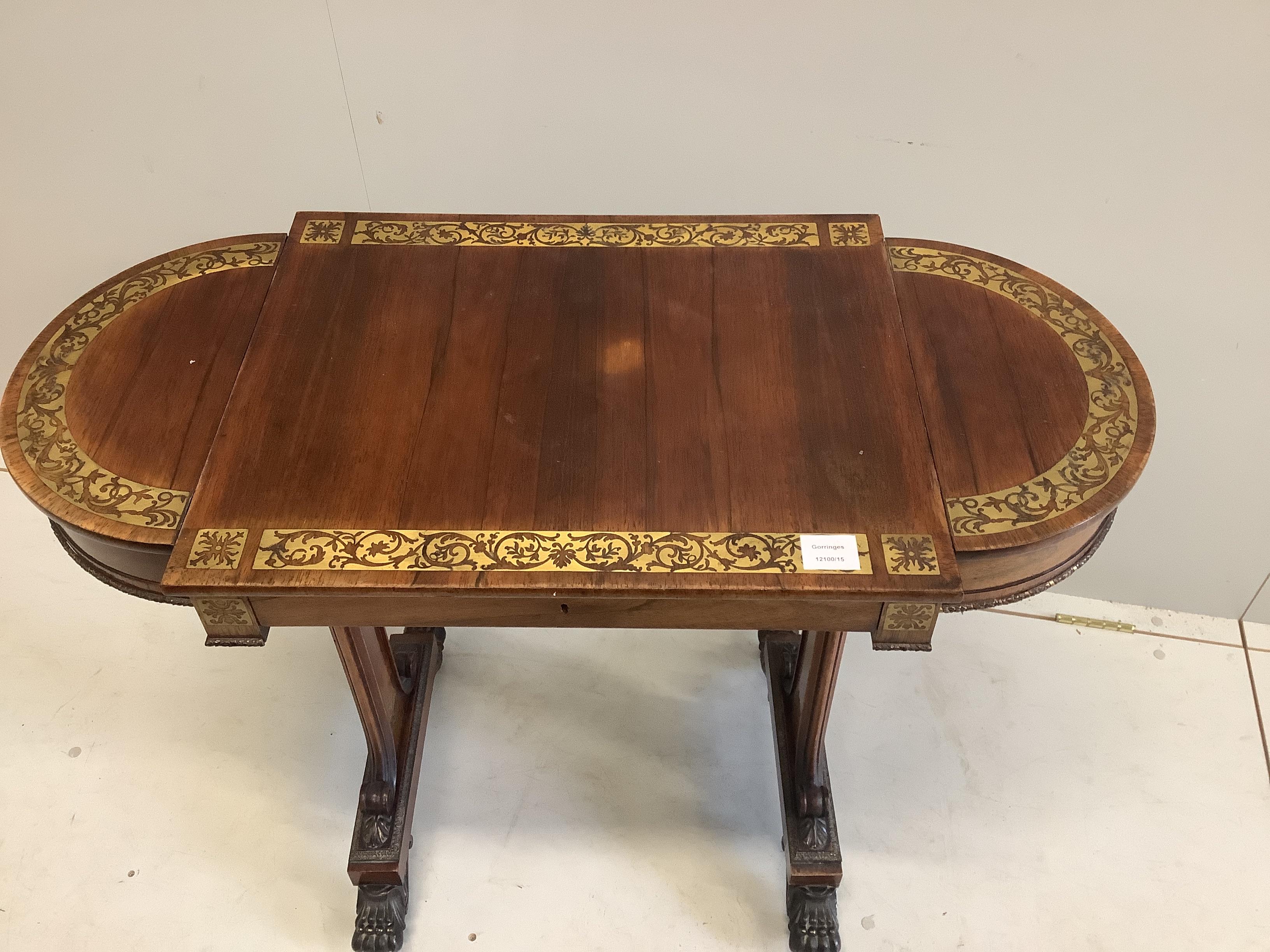 A Regency cut brass inlaid rosewood table with twin hinged flap top, lacks silks box, width 94cm, depth 46cm, height 73cm